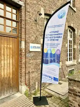 Beach flag T²D²-PME à l'entrée des Ateliers de l'UCLouvain en Hainaut à Mons